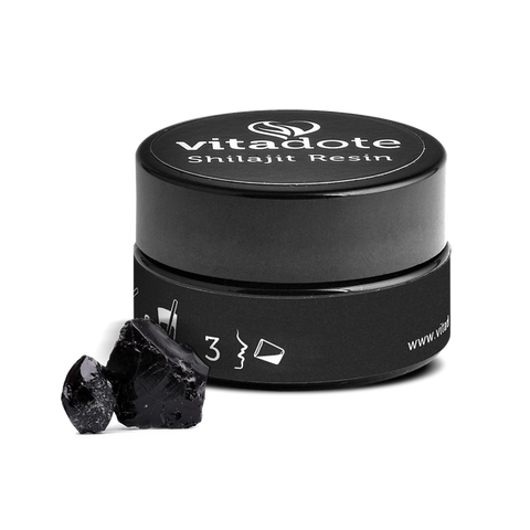 Black container of Vitadote Shilajit Resin with two pieces of black resin on a white background