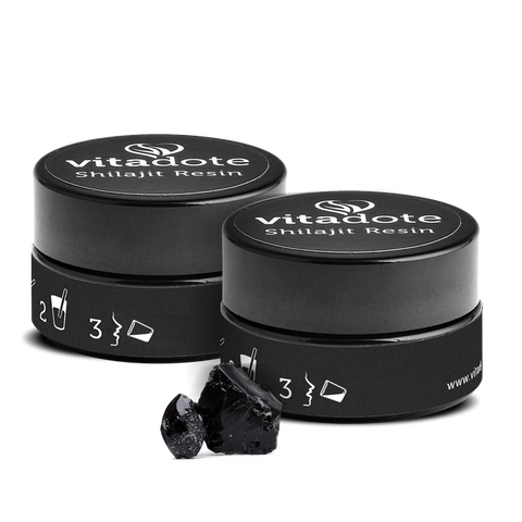 Two black containers of vitadote Shilajit Resin with some resin on a white background