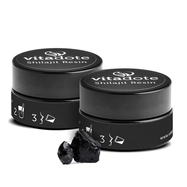 Two black containers of vitadote Shilajit Resin with some resin on a white background